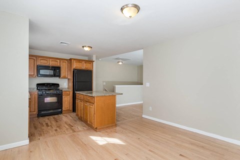 A kitchen with wooden cabinets and a black oven.