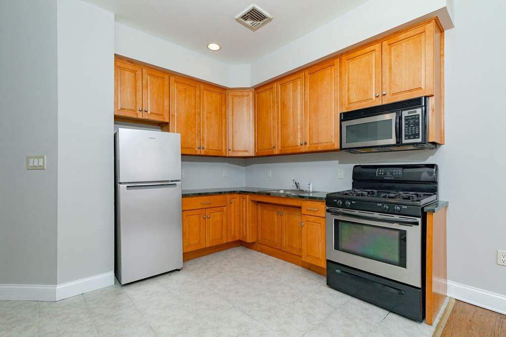 A kitchen with wooden cabinets and black appliances.