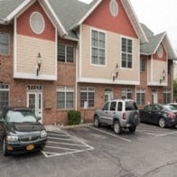 A red and white building with a parking lot in front.