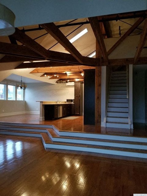A large open space with wooden floors and a staircase.