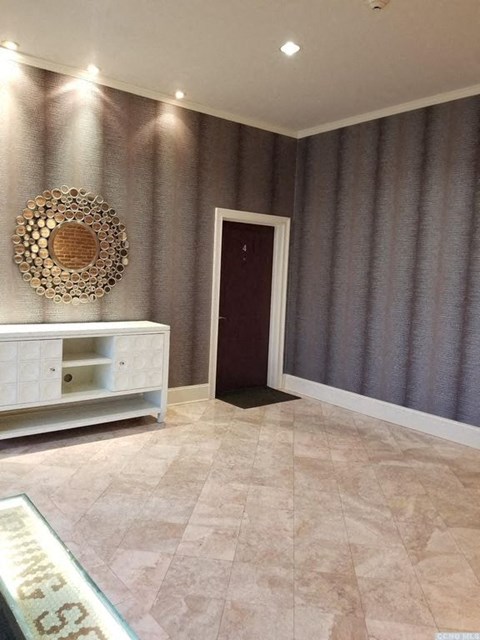 A room with a white cabinet and a mirror on the wall.