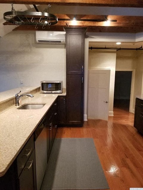 A kitchen with a sink and a microwave.