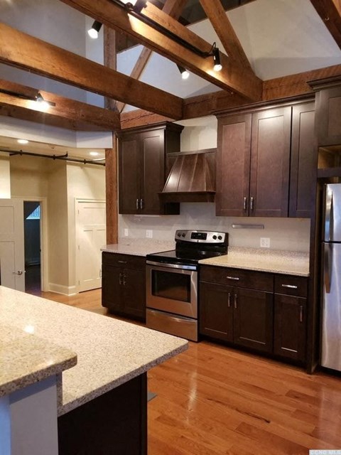 A kitchen with wooden cabinets and a white counter top.