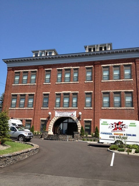A brick building with a sign in front that says "Clubs".