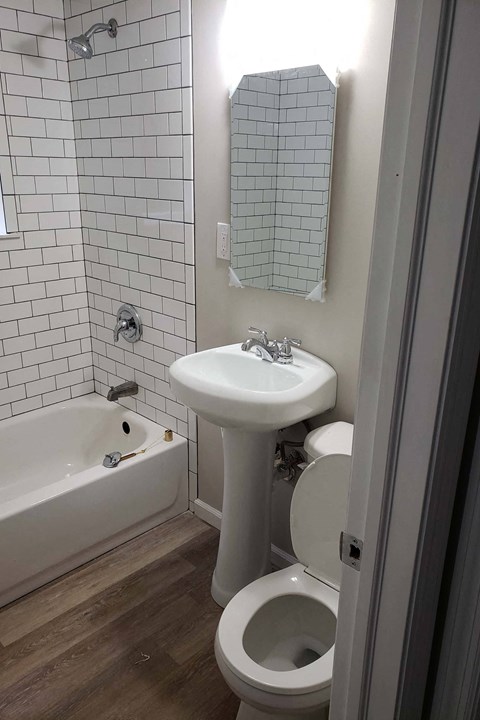 A white toilet sits next to a white sink in a bathroom.