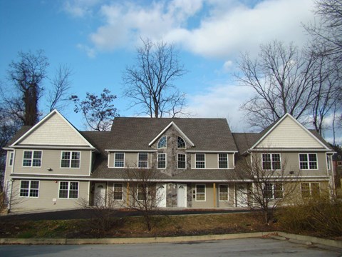 A large, two-story house with a grey and white exterior.
