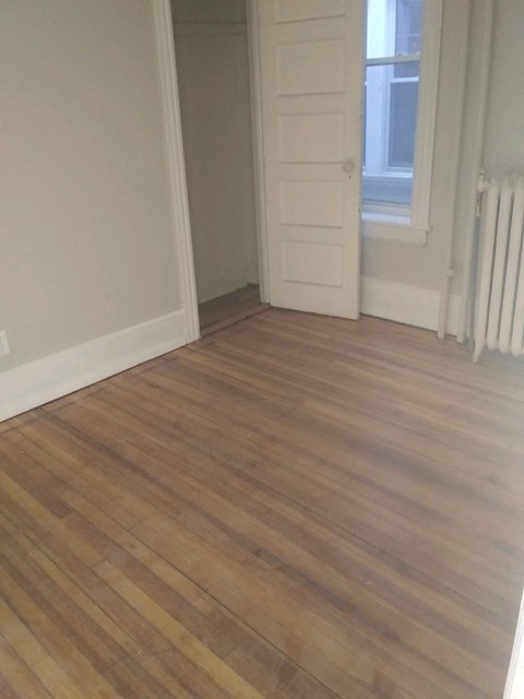 A room with a wooden floor and a white door.