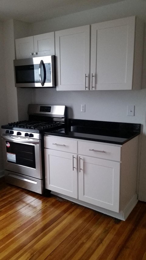 A kitchen with a stove top oven and microwave.