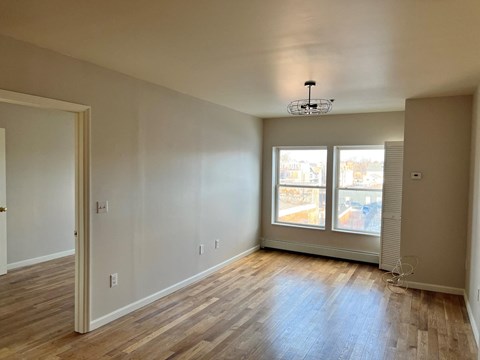 A room with wooden floors and a ceiling fan.