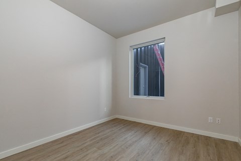 A room with a window and wooden flooring.
