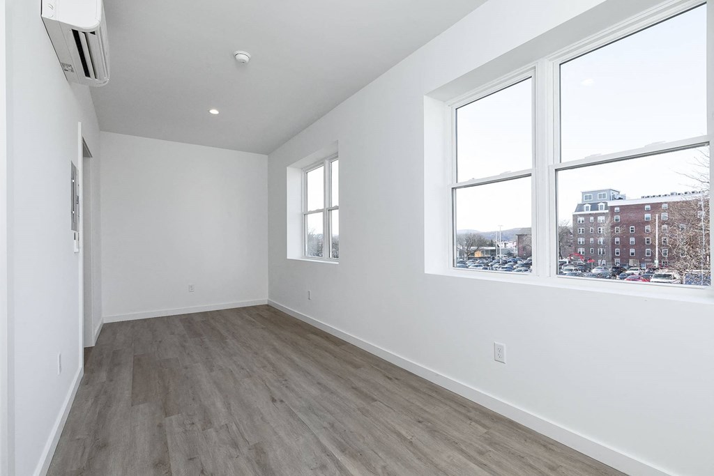A room with a window and a wall-mounted air conditioner.