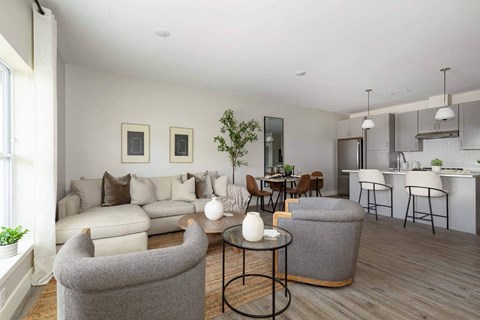A modern living room with a grey sofa and a glass coffee table.
