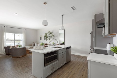 A modern kitchen with a white countertop and grey cabinets.