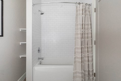 A white bathroom with a shower curtain.