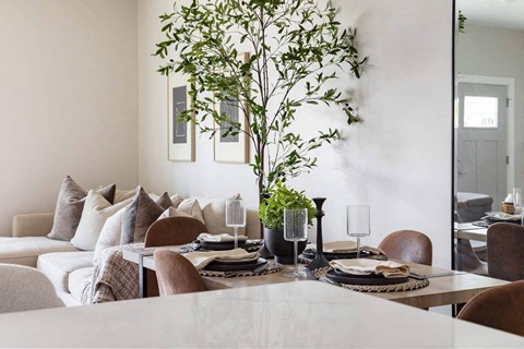 A dining room with a table set for a meal.