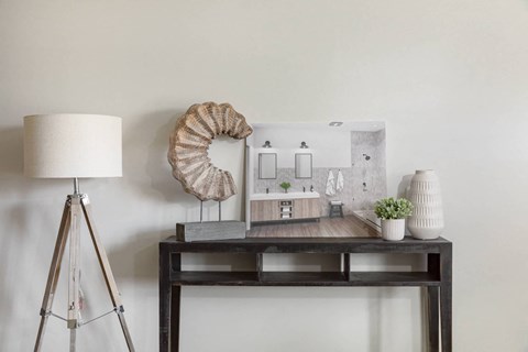 A table with a lamp, a plant, and a model of a house.