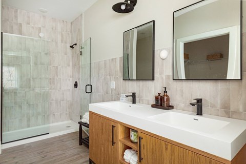 A bathroom with a white sink and a glass shower.