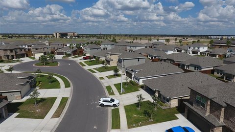 A residential area with houses and a car on the road.