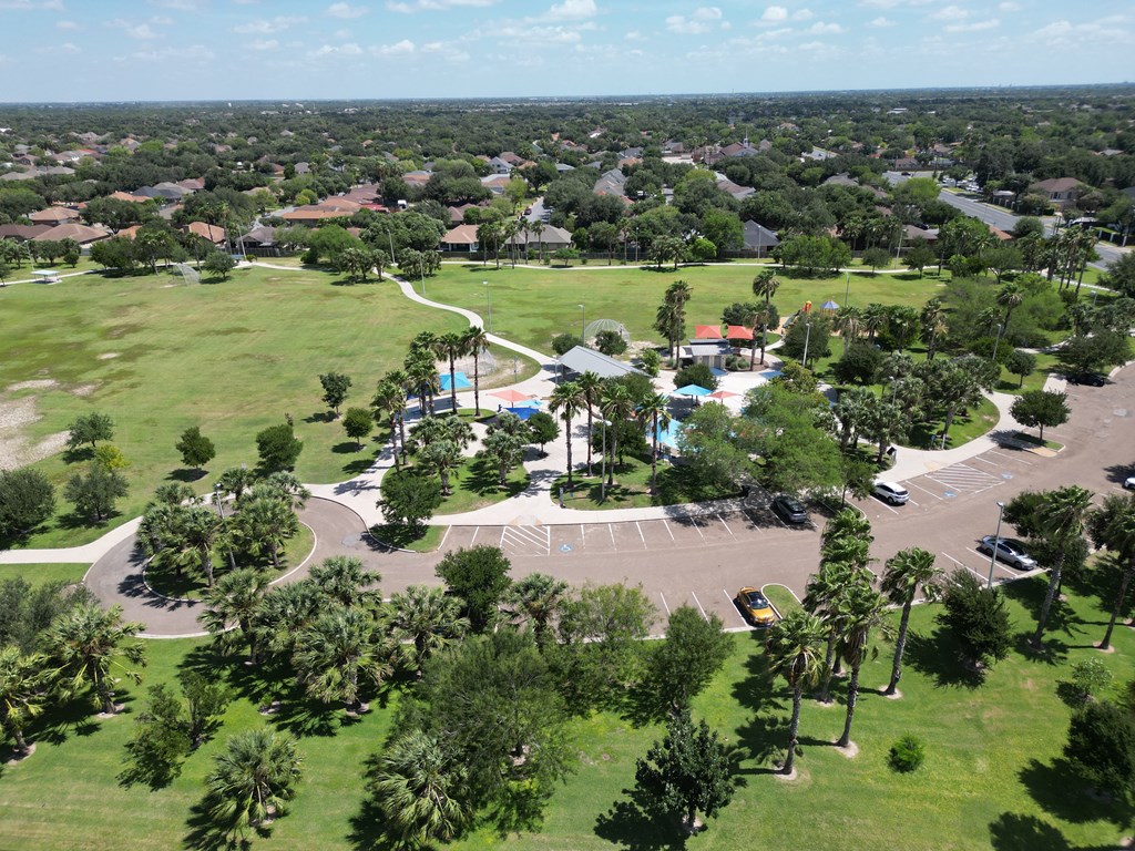 A bird's eye view of a residential area with a swimming pool and a parking lot.