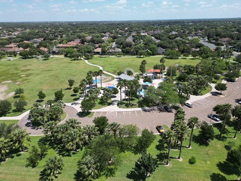 A bird's eye view of a residential area with a swimming pool and a parking lot.