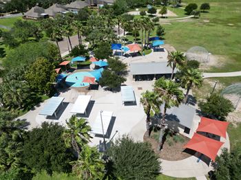 A park with a playground and picnic tables.