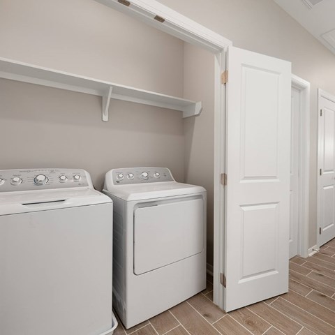 A white washing machine and dryer in a laundry room.