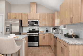 A modern kitchen with wooden cabinets and stainless steel appliances.