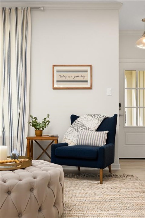 A living room with a blue couch and a framed picture on the wall.
