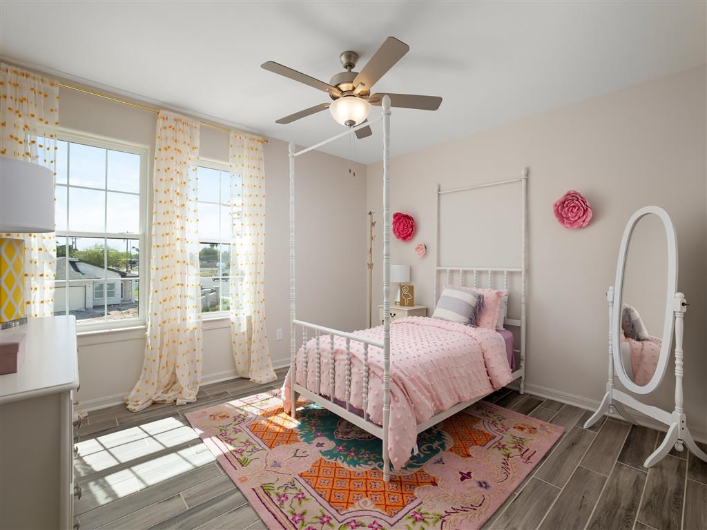 A bedroom with a pink bed and a white canopy bed.