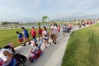 A group of people are walking down a path holding American flags.