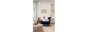 A living room with a blue sofa and a framed picture on the wall.