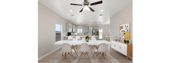 A dining room with a white table and chairs.
