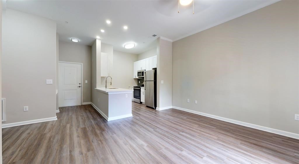 A kitchen area with a white countertop and wooden flooring. at Vue at Embry Hills, Atlanta, GA, 30042