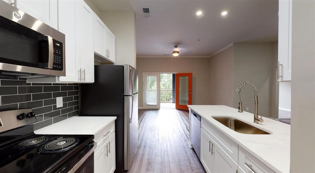 A kitchen with black and white appliances at Vue at Embry Hills, Atlanta, GA