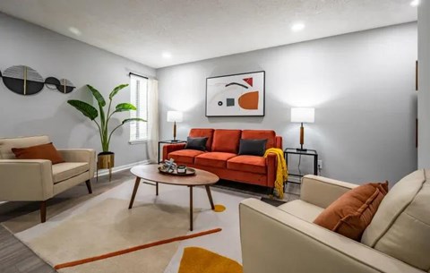 A living room with a red couch and a white sofa.