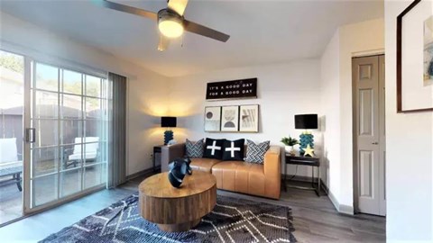 A living room with a brown leather sofa and a wooden coffee table.