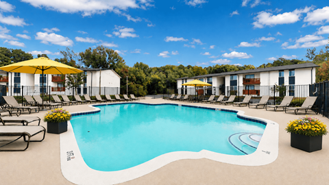 A large outdoor swimming pool surrounded by lounge chairs and umbrellas.