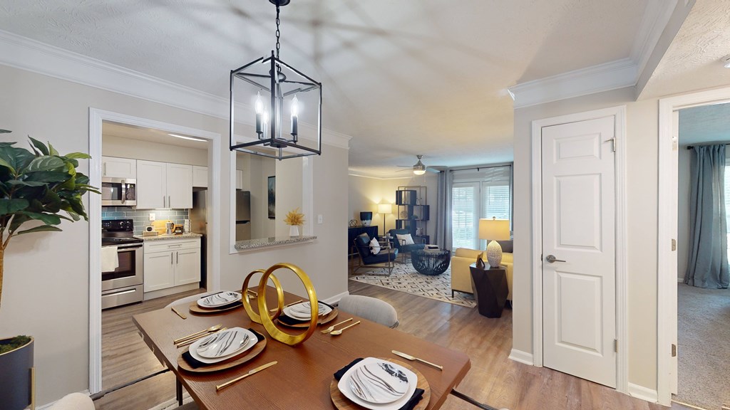 A dining room with a wooden table set for two.