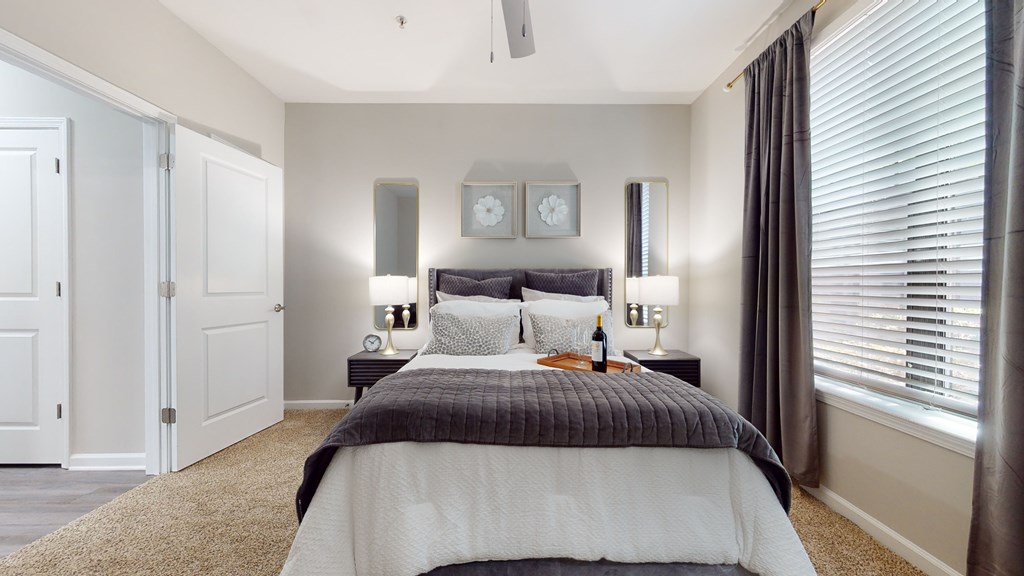 A bedroom with a bed, two lamps, and a clock on the wall at Embry Hills, GA, 30042