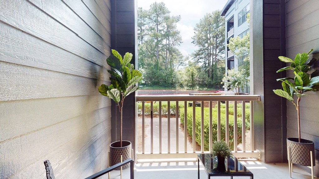 A balcony with a table and two potted plants at Embry Hills, Atlanta, 30042
