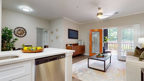 A modern kitchen with a stainless steel dishwasher and a glass coffee table.