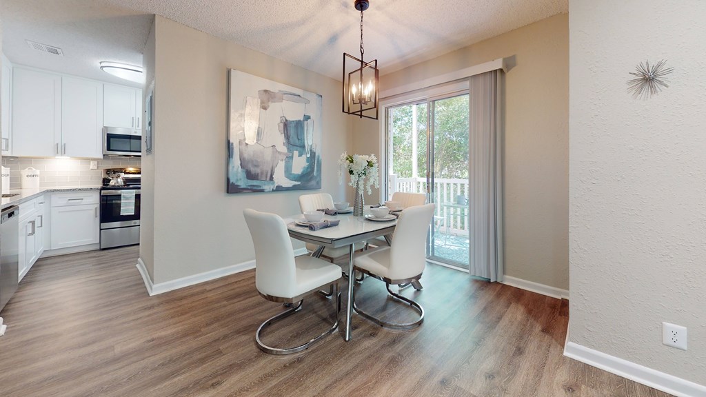 A dining room with a table and chairs.