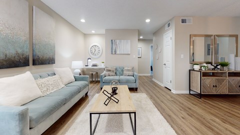 A living room with a blue couch and a wooden coffee table.