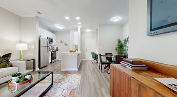 A modern living room with a glass coffee table and a wooden bookshelf. at Vue at Embry Hills, Atlanta, Georgia