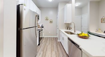 A kitchen with white cabinets and a stainless steel refrigerator. at Vue at Embry Hills, Georgia, 30042