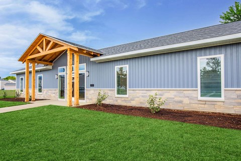 A modern house with a wooden porch and grey siding.