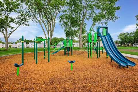 A playground with a green slide and a blue slide.