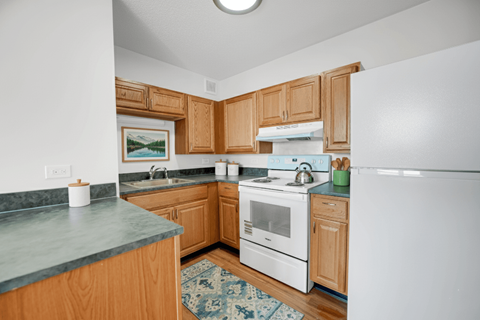 A kitchen with wooden cabinets and a white refrigerator.
