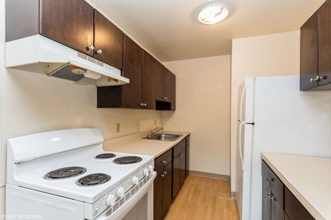 A kitchen with a white stove and a white refrigerator. A kitchen with a white stove and a white refrigerator at Mohican Apartments, Connecticut, 06320