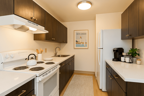 A kitchen with a white stove top and a white refrigerator. A kitchen with a white stove top and a white refrigerator at Mohican Apartments, Connecticut, 06320